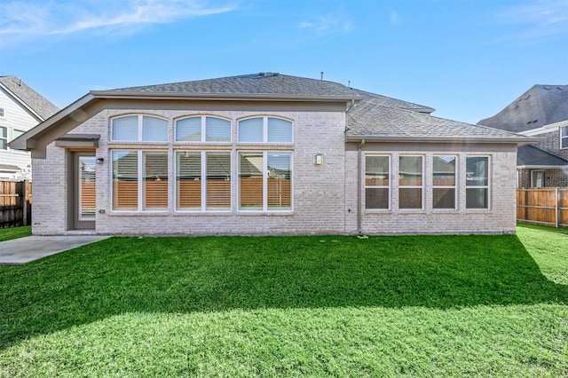 rear view of house featuring a yard