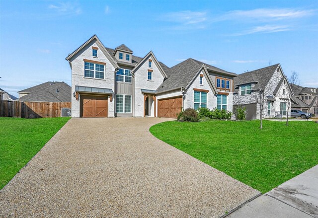 view of front of home featuring a front yard, a garage, and central air condition unit