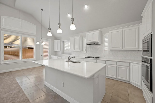 kitchen with a center island with sink, white cabinets, light tile patterned floors, and appliances with stainless steel finishes