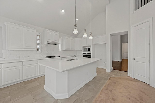 kitchen with sink, stainless steel appliances, pendant lighting, a center island with sink, and white cabinets