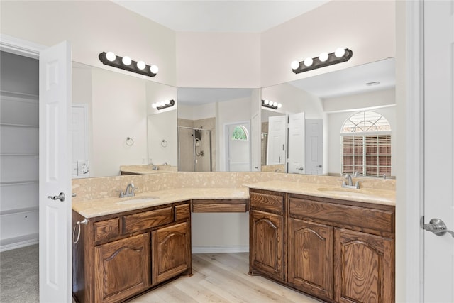 bathroom featuring a shower with door, vanity, and wood-type flooring