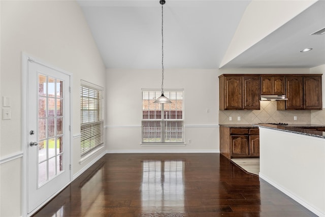 kitchen featuring tasteful backsplash, dark brown cabinets, hanging light fixtures, and vaulted ceiling