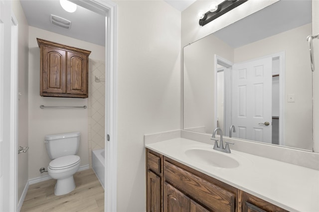 full bathroom with bathtub / shower combination, wood-type flooring, vanity, and toilet