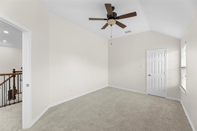 carpeted spare room with ceiling fan and vaulted ceiling