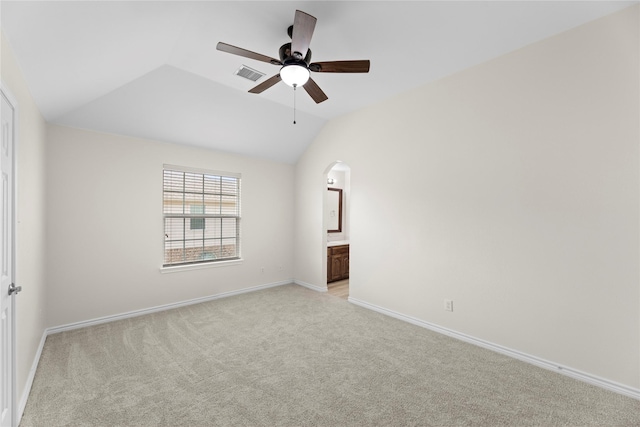 carpeted spare room featuring vaulted ceiling and ceiling fan