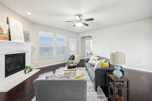 living room with ceiling fan and dark hardwood / wood-style flooring