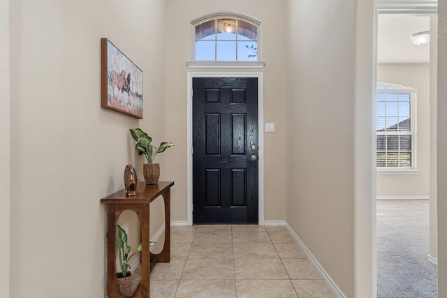 foyer entrance with light tile patterned flooring and a healthy amount of sunlight