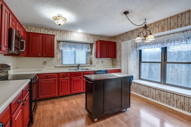 kitchen featuring pendant lighting, a center island, an inviting chandelier, black appliances, and sink