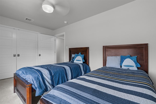 carpeted bedroom featuring ceiling fan and a closet