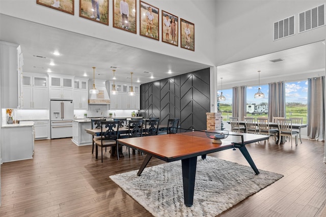 dining room featuring a towering ceiling and dark hardwood / wood-style floors