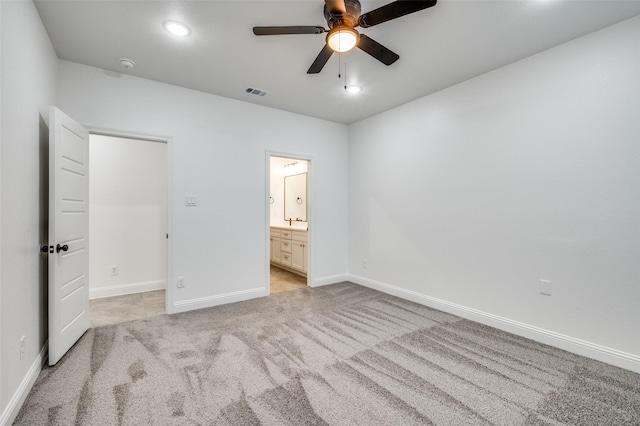 unfurnished bedroom with ceiling fan, connected bathroom, and light carpet