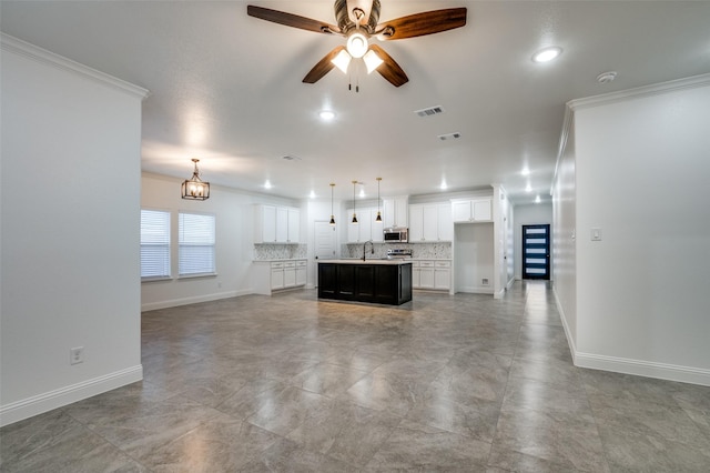 unfurnished living room featuring sink, ceiling fan with notable chandelier, and ornamental molding