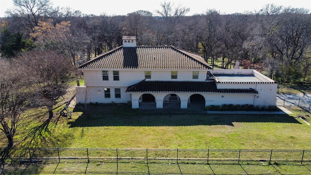 rear view of property featuring a lawn