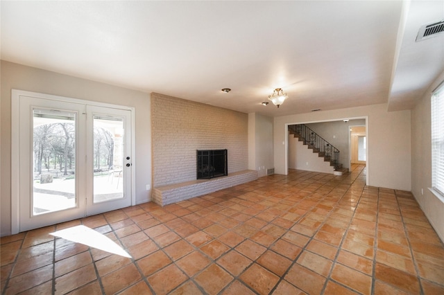 unfurnished living room with a fireplace and light tile patterned flooring