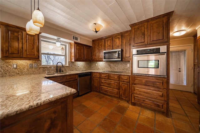 kitchen with sink, hanging light fixtures, stainless steel appliances, light stone counters, and backsplash