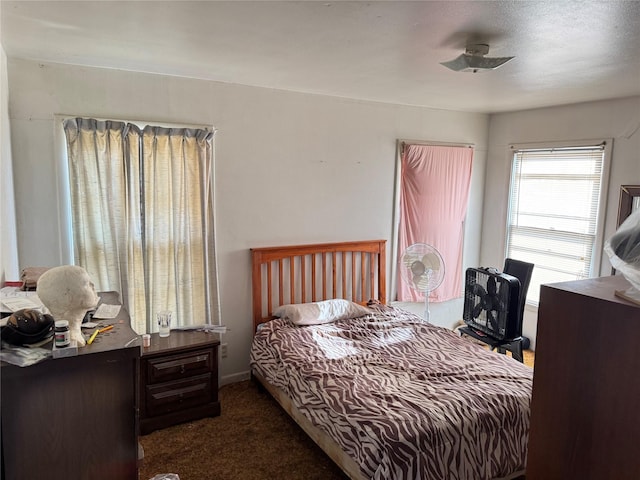 bedroom with ceiling fan and dark carpet