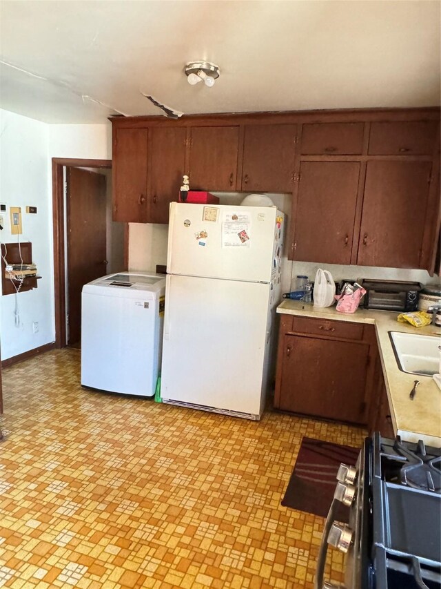 kitchen featuring stove, white refrigerator, fridge, and sink