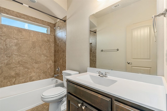 full bathroom featuring vanity, tiled shower / bath, and toilet