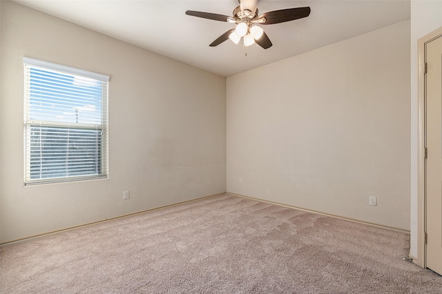 spare room featuring light carpet and ceiling fan