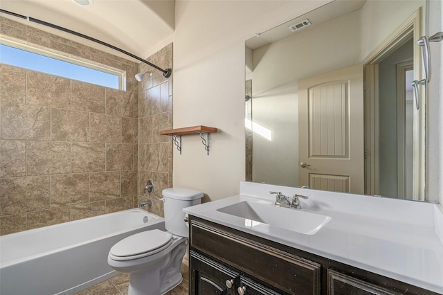 full bathroom featuring tiled shower / bath, vanity, toilet, and tile patterned flooring