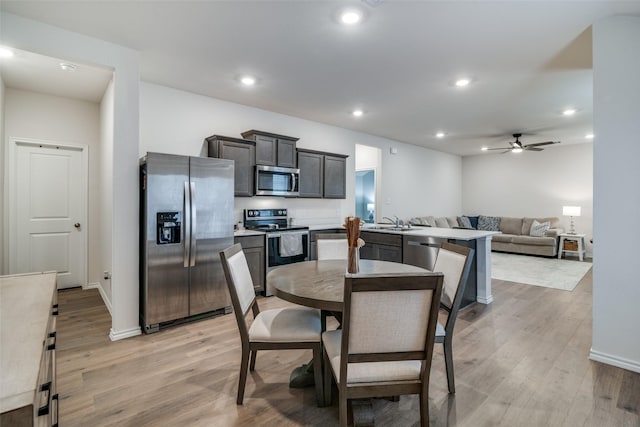 dining room with sink, light hardwood / wood-style floors, and ceiling fan