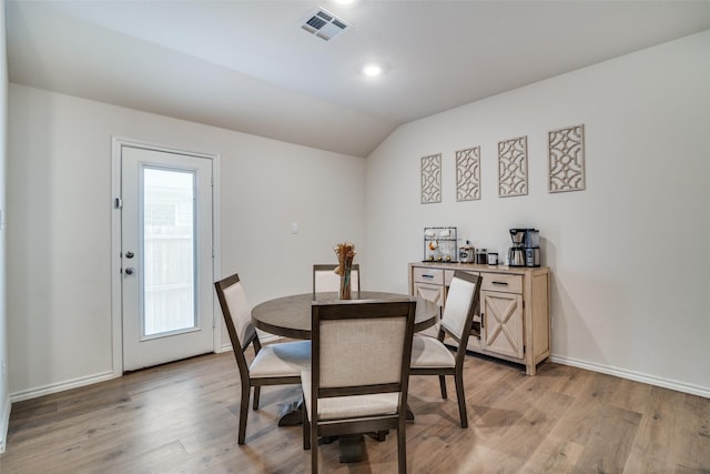 dining space with lofted ceiling and light wood-type flooring