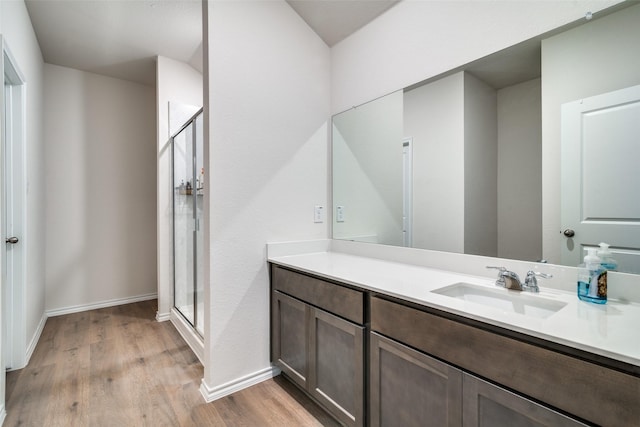 bathroom featuring vanity, wood-type flooring, and walk in shower