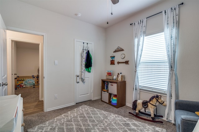 carpeted entrance foyer featuring a wealth of natural light and ceiling fan