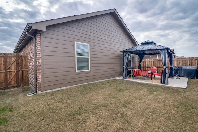 back of house with a gazebo, a yard, and a patio