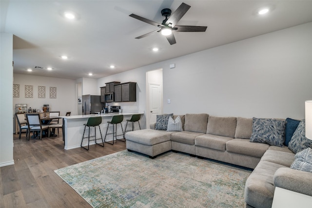 living room with ceiling fan and light hardwood / wood-style floors