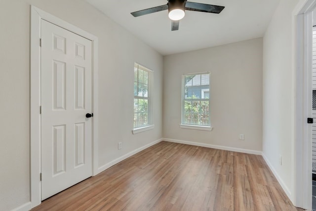 empty room with ceiling fan and light hardwood / wood-style flooring