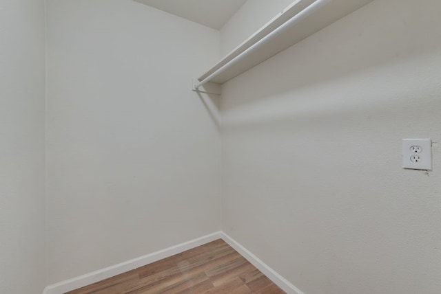 walk in closet with wood-type flooring