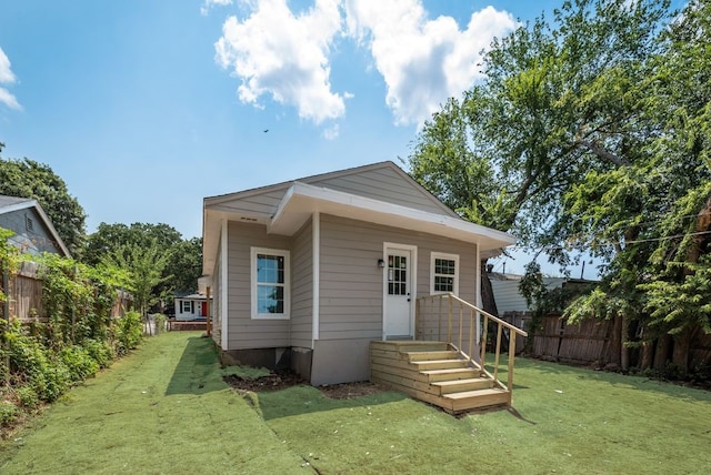 rear view of house featuring a lawn