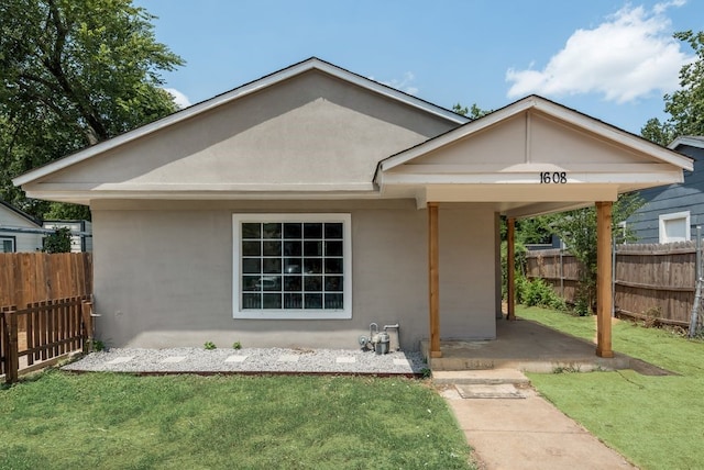 ranch-style house with a patio and a front yard