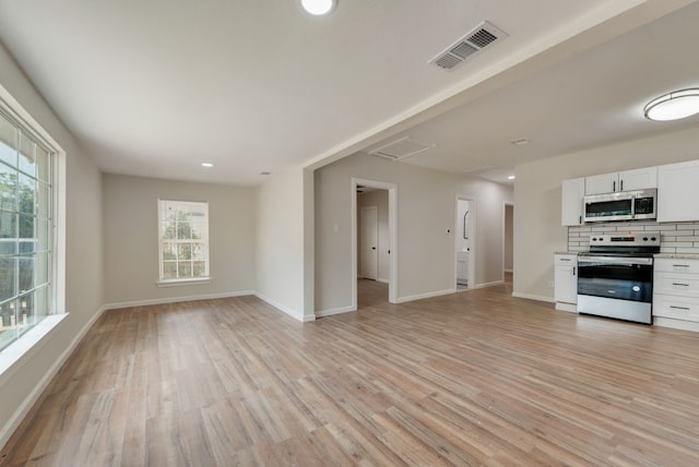 unfurnished living room with light hardwood / wood-style floors and a wealth of natural light