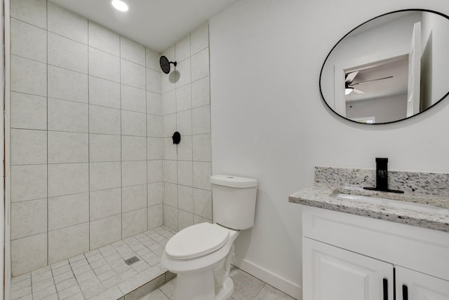 bathroom with vanity, tile patterned floors, toilet, and a tile shower