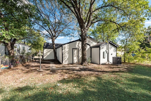 view of outbuilding with central AC unit and a lawn