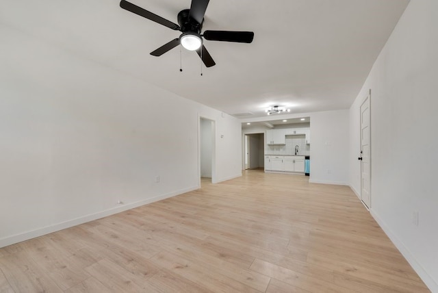 unfurnished living room featuring ceiling fan, light wood-type flooring, and sink