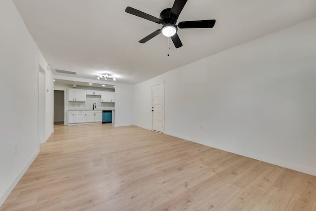 unfurnished living room featuring sink, light hardwood / wood-style flooring, and ceiling fan