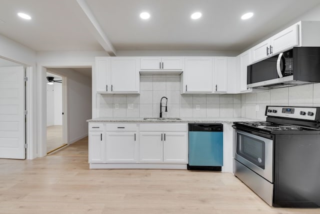 kitchen featuring white cabinetry, sink, stainless steel appliances, and light stone countertops