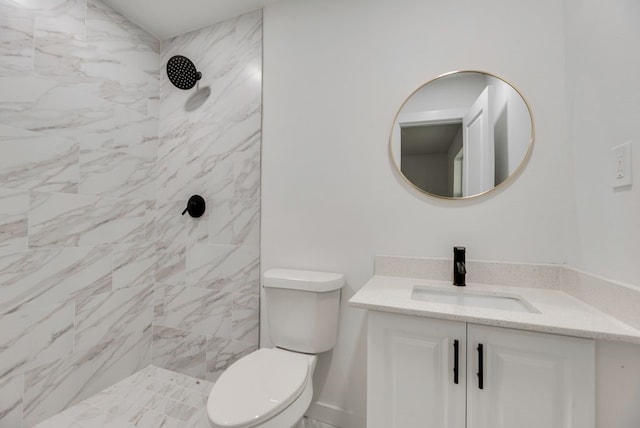 bathroom featuring tiled shower, vanity, and toilet