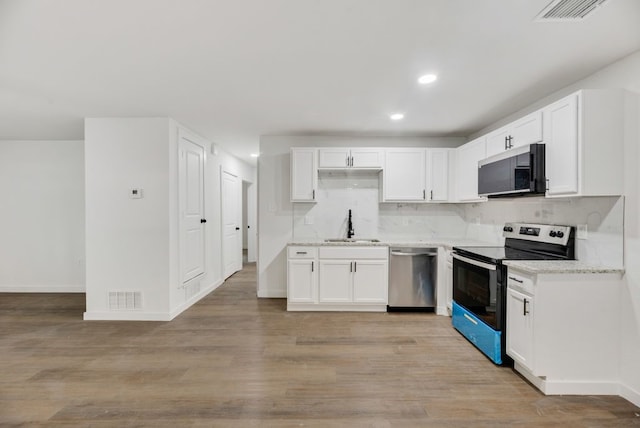 kitchen with appliances with stainless steel finishes, tasteful backsplash, white cabinetry, and sink