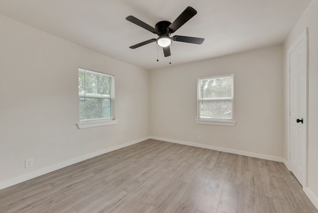 spare room featuring a wealth of natural light, ceiling fan, and light hardwood / wood-style floors