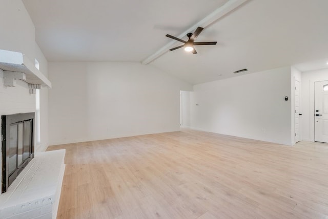 unfurnished living room with vaulted ceiling with beams, ceiling fan, a fireplace, and light wood-type flooring