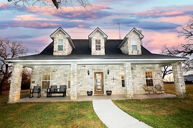 cape cod house with a yard and a patio area