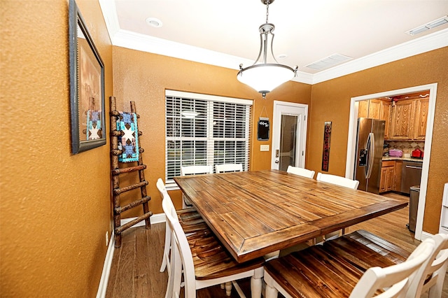 dining area with light hardwood / wood-style flooring and ornamental molding