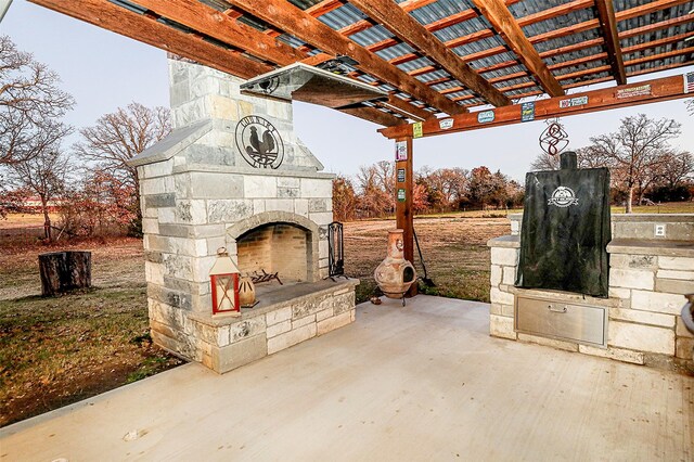 view of patio with a pergola and an outdoor stone fireplace