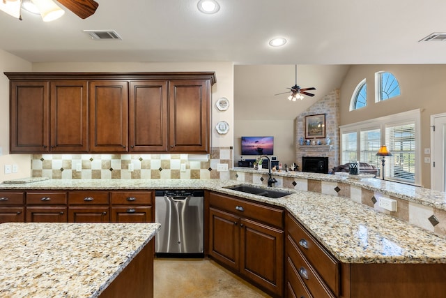 kitchen featuring light stone countertops, a large fireplace, sink, lofted ceiling, and decorative backsplash