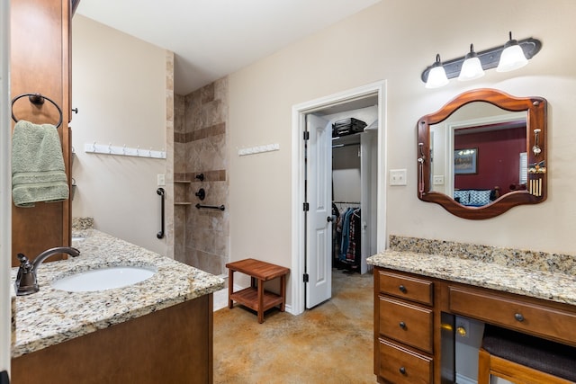 bathroom with a shower, vanity, and concrete floors