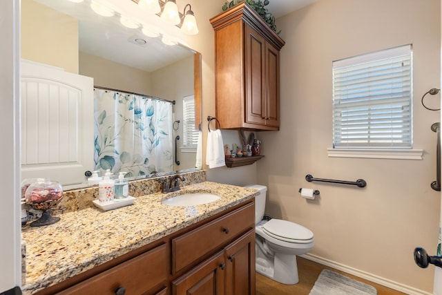 bathroom featuring a shower with shower curtain, vanity, and toilet